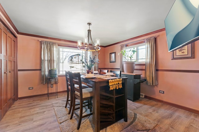 dining area featuring ornamental molding, light wood-type flooring, and baseboards