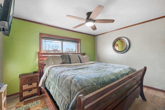 bedroom with ornamental molding, wood finished floors, a ceiling fan, and baseboards