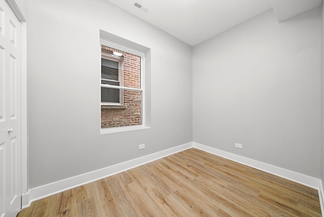 spare room featuring baseboards, light wood finished floors, and visible vents