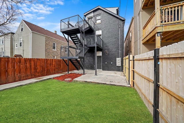 view of yard with a patio, a fenced backyard, stairway, and a deck