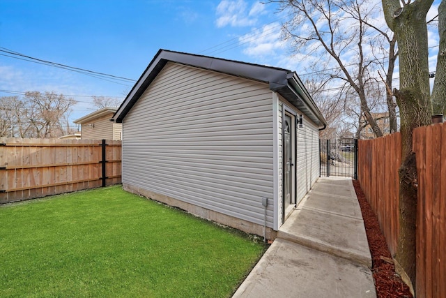 exterior space with a gate, fence, and a lawn