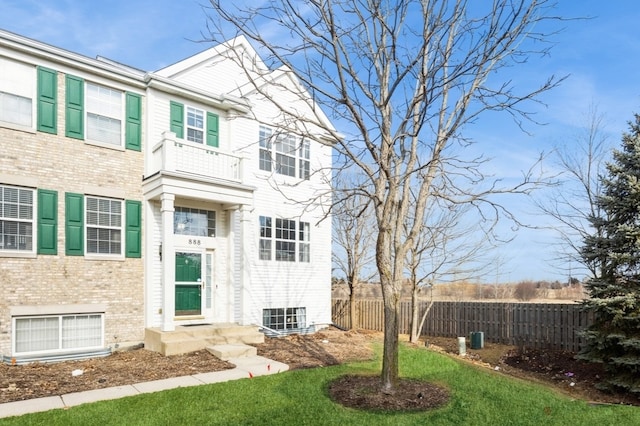 view of front of home with a front yard and fence