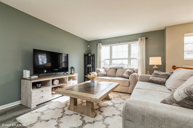 living room with lofted ceiling, plenty of natural light, wood finished floors, and baseboards