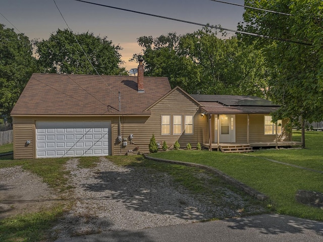 view of front of home with dirt driveway, a porch, roof mounted solar panels, a garage, and a front lawn