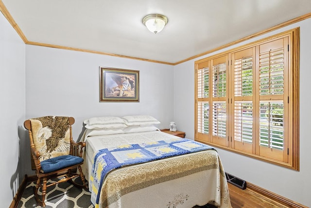 bedroom featuring multiple windows, visible vents, crown molding, and wood finished floors