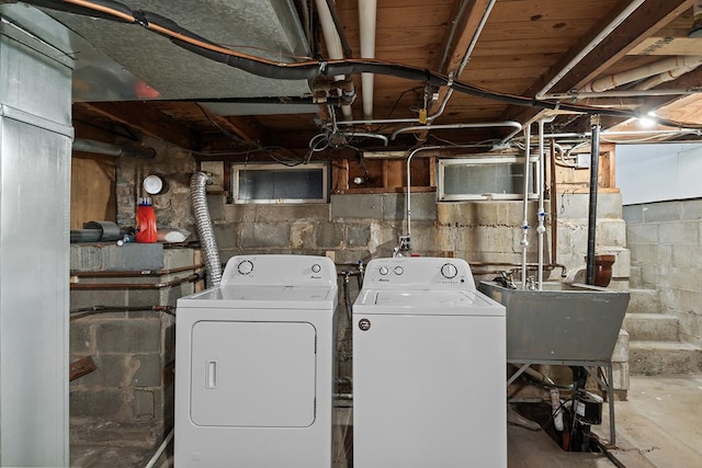 clothes washing area with laundry area, independent washer and dryer, and a sink