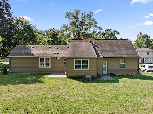 back of property featuring a yard, cooling unit, and a patio