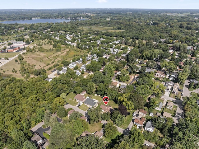 drone / aerial view featuring a water view, a residential view, and a view of trees