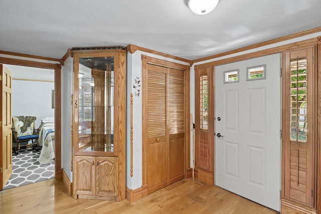 entrance foyer with ornamental molding and light wood finished floors