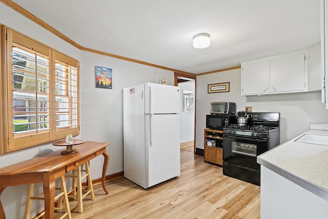 kitchen featuring white cabinets, light wood-style floors, ornamental molding, light countertops, and black appliances