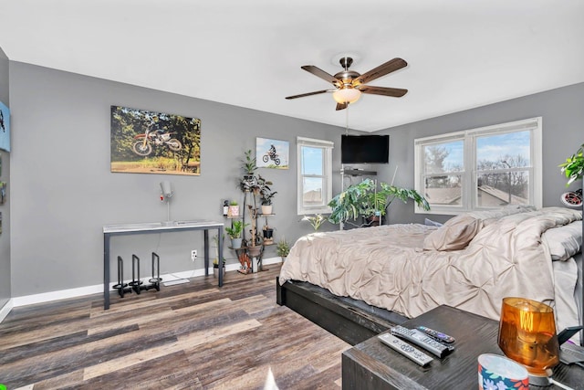 bedroom featuring a ceiling fan, baseboards, and wood finished floors