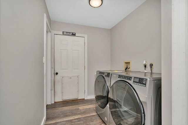 washroom with laundry area, baseboards, washing machine and clothes dryer, and wood finished floors