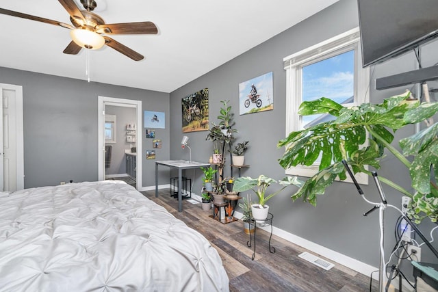 bedroom featuring ceiling fan, ensuite bathroom, wood finished floors, visible vents, and baseboards