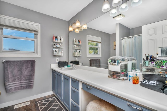 full bathroom featuring a shower with shower curtain, wood finished floors, vanity, visible vents, and baseboards