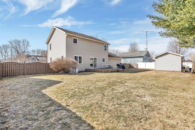 rear view of property with a fenced backyard, a storage unit, a lawn, and an outdoor structure