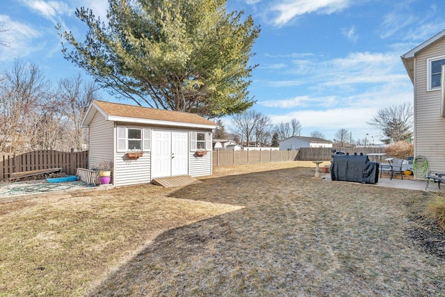 view of yard with an outbuilding, a patio area, and a fenced backyard