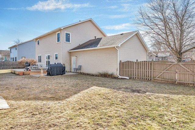 back of property with a patio, a lawn, and fence