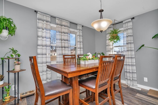 dining room with baseboards and wood finished floors