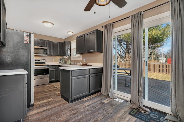 kitchen with dark wood finished floors, light countertops, appliances with stainless steel finishes, a ceiling fan, and a sink