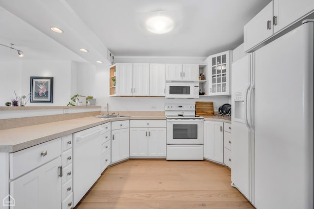 kitchen with light wood finished floors, open shelves, white cabinets, a sink, and white appliances