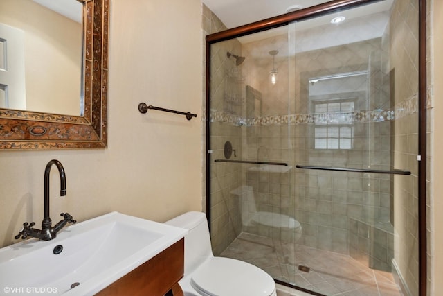 bathroom featuring a shower stall, toilet, and vanity