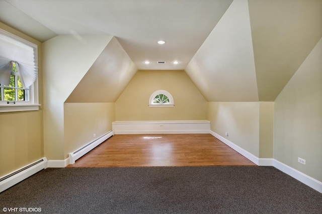 additional living space with a baseboard heating unit, lofted ceiling, plenty of natural light, and baseboard heating