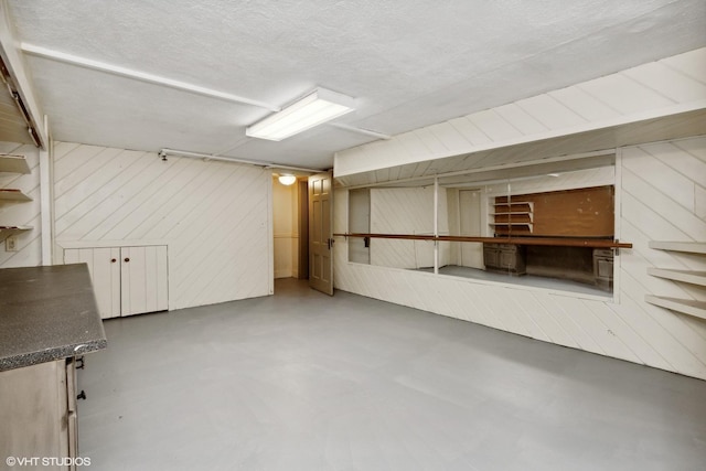 finished basement with wood walls and a textured ceiling