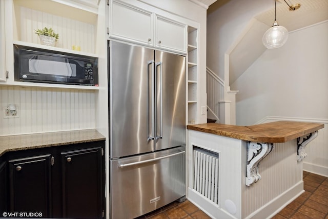 kitchen featuring open shelves, high end fridge, wooden counters, black microwave, and dark cabinetry