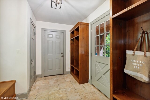 mudroom with baseboards and light tile patterned floors