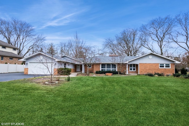 single story home with a garage, brick siding, fence, driveway, and a front lawn