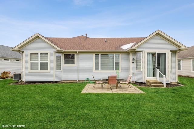 rear view of property with a shingled roof, a patio area, a yard, and central air condition unit