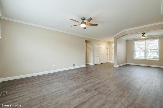 spare room featuring ornamental molding, wood finished floors, visible vents, and baseboards