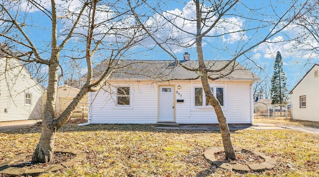 bungalow-style home with a shingled roof and a front yard