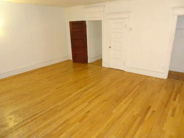 unfurnished bedroom with baseboards and light wood-style floors