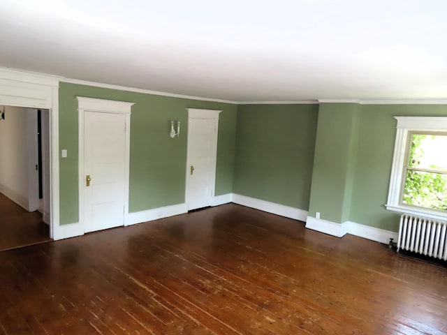 empty room with radiator, baseboards, ornamental molding, and dark wood-type flooring