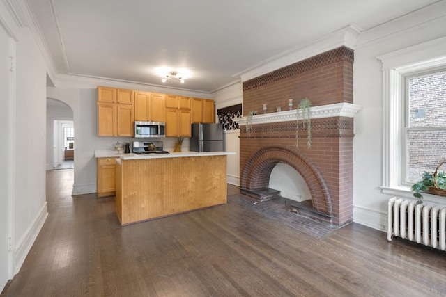 kitchen with dark wood-style floors, radiator heating unit, stainless steel microwave, stove, and freestanding refrigerator