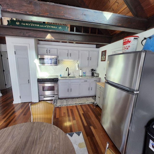 kitchen featuring tasteful backsplash, white cabinets, dark wood-style floors, stainless steel appliances, and beam ceiling