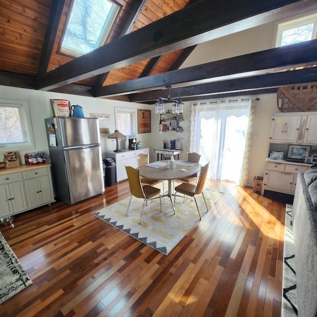 dining space featuring dark wood-style flooring and lofted ceiling with beams