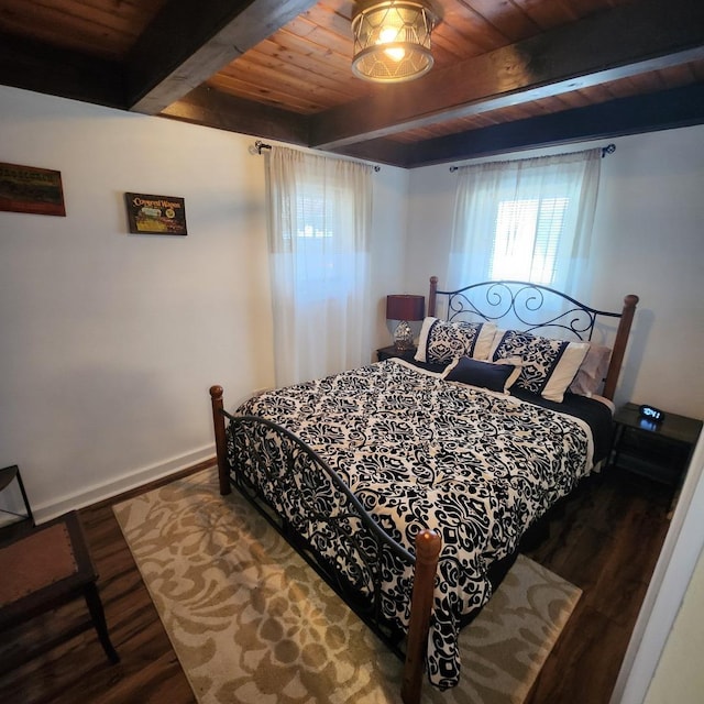 bedroom with beamed ceiling, wood finished floors, wood ceiling, and baseboards