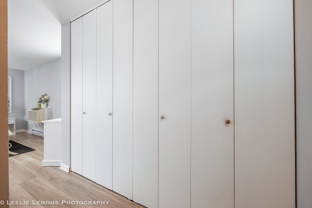 closet with an AC wall unit and baseboard heating