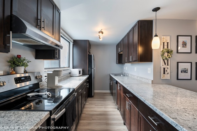 kitchen featuring light countertops, light wood-style flooring, appliances with stainless steel finishes, dark brown cabinets, and under cabinet range hood