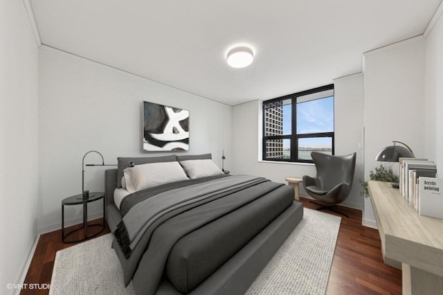 bedroom with dark wood-style floors and baseboards