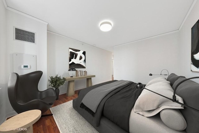 bedroom featuring ornamental molding, wood finished floors, and visible vents