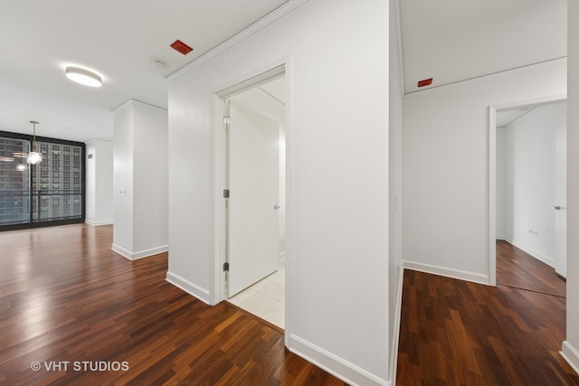 corridor with baseboards and wood finished floors