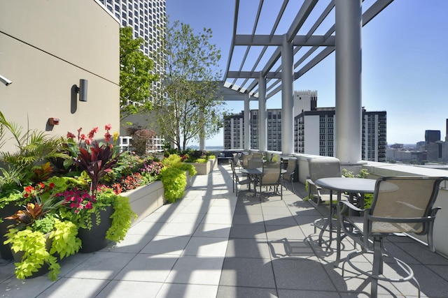 view of patio with a view of city, a pergola, and outdoor dining space