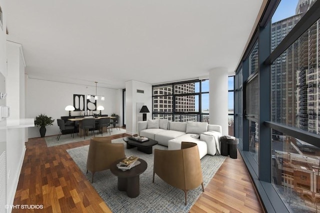 living room featuring visible vents, floor to ceiling windows, and wood finished floors