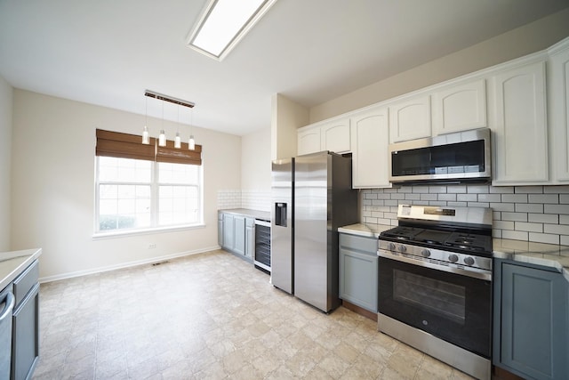 kitchen with wine cooler, light countertops, backsplash, appliances with stainless steel finishes, and white cabinets