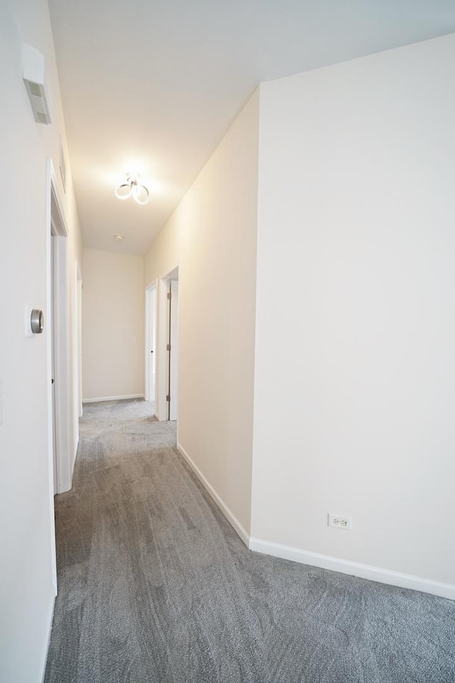 hall featuring carpet and baseboards