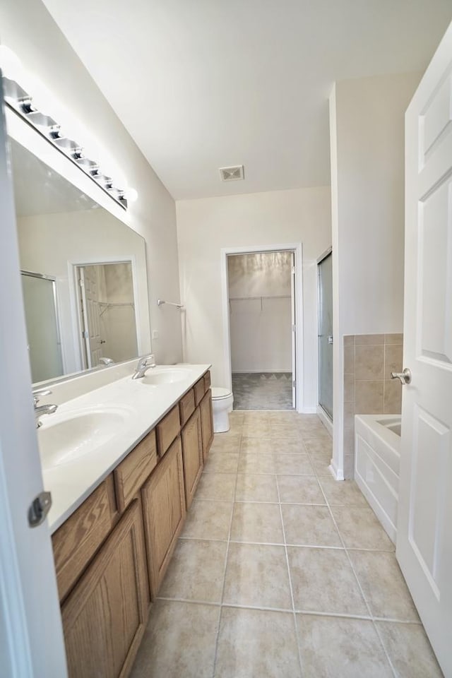 full bath featuring a stall shower, tile patterned flooring, a sink, and visible vents