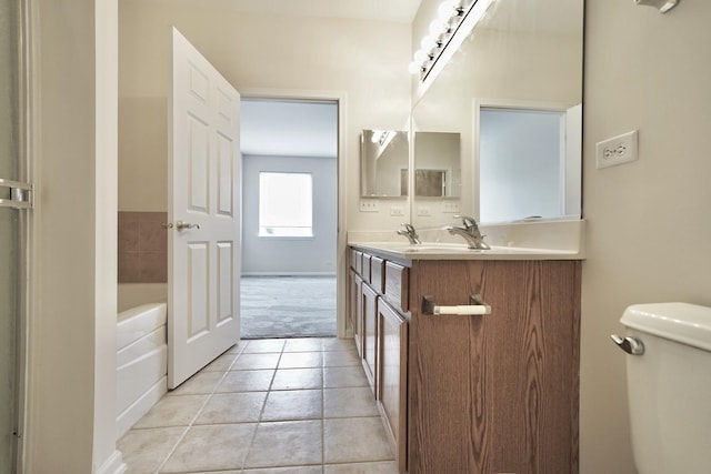 bathroom with double vanity, toilet, a sink, tile patterned flooring, and a bath